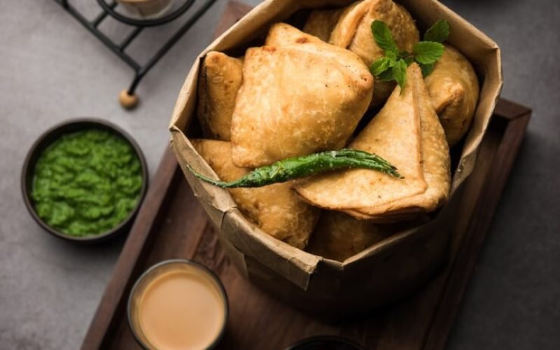 samosa-triangle-shape-fried-baked-pastry-with-savoury-filling-popular-indian-tea-time-snacks-served-with-green-chutney-tomato-ketchup_466689-2463